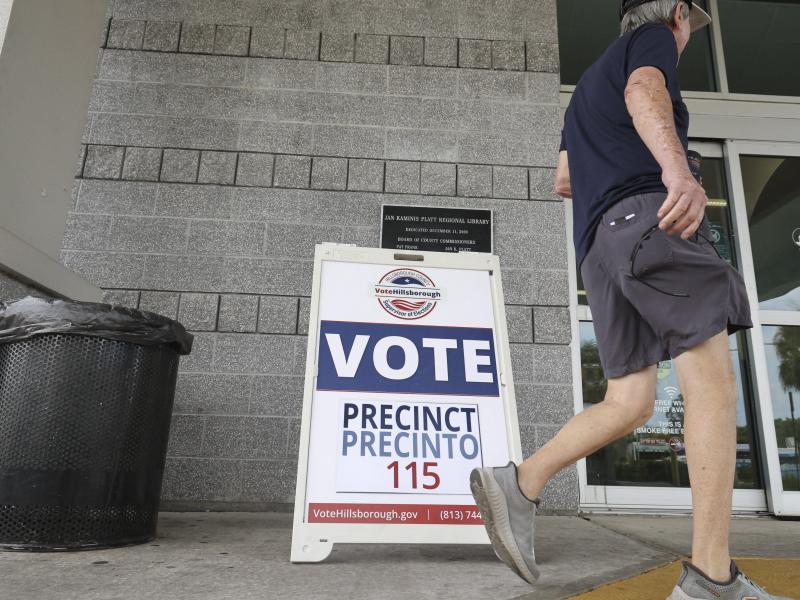 A man walks by a "Vote" sign outside of a Florida polling place