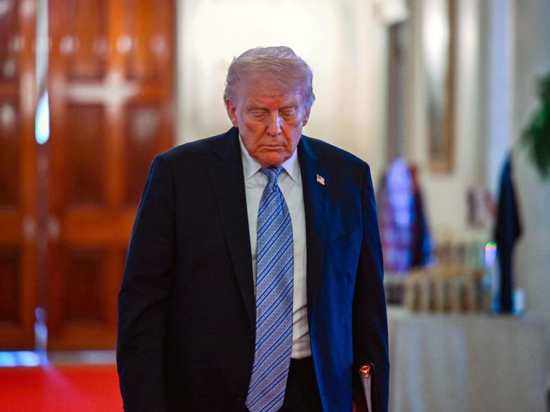 President Donald Trump walks inside the White House